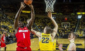 Ohio State forward Jae'Sean Tate attempts to score while defended by Michigan guard Duncan Robinson during Sunday's game in Ann Arbor, Mich. Michigan won the game, 74-62.