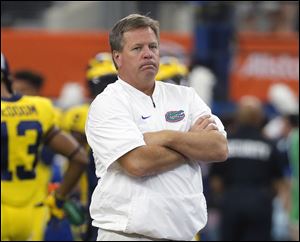 This is a Sept. 2, 2017, file photo showing Florida head coach Jim McElwain watching his team warm up. McElwain is now working at Michigan and could receive a pay raise after just one week.