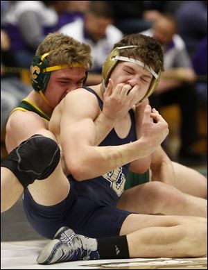 St. John's Timothy Marshall, front, gets fingers in his face by Clay's Jacob Meek as they wrestle at 182 pounds during the finals of the district wrestling tournament at Perrysburg High School on Saturday, March 3, 2018.