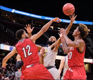 Toledo guard Tre'Shaun Fletcher shoots between Miami's Darrian Ringo (12) and Dalonte Brown during a MAC tournament quarterfinal game Thursday, March 8, 2018, at Quicken Loans Arena in Cleveland.