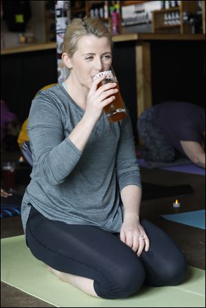Laura Deiger takes a drink of her beer during a break in a yoga session Saturday, March 10, 2018, at Earnest Brew Works in Toledo.