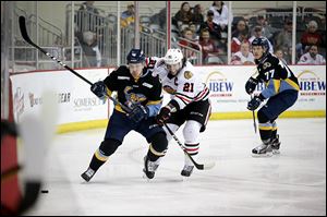 Indy Fuel forward Michael Neal battles for a loose puck with Toledo Walleye forward Colin Jacobs during Game 3 of the Central Division semifinals at Indiana Farmers Coliseum in Indianapolis.