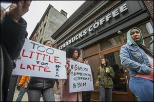 Protesters gather outside of a  Starbucks in Philadelphia where two black men were arrested after employees called police to say the men were trespassing.