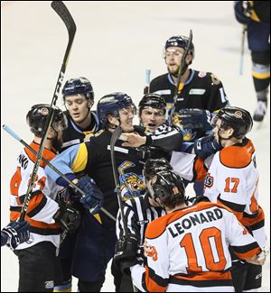 Officials break up a skirmish between Toledo Walleye defender Jared Wilson and Fort Wayne Komets players Bobby Shea (17) and Curtis Leonard during a game this season. The Central Division final series between the two teams begins Saturday at the Huntington Center in downtown Toledo.