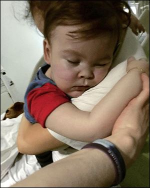 In this April 23, 2018 handout photo provided by Alfies Army Official, brain-damaged toddler Alfie Evans cuddles his mother Kate James at Alder Hey Hospital, Liverpool, England.
