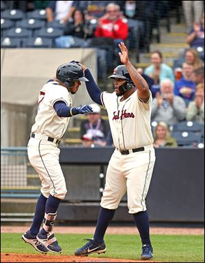 Hens infielder Edwin Espinal greets shortstop Harold Castro after Castro's two-run home run in the seventh inning Sunday.