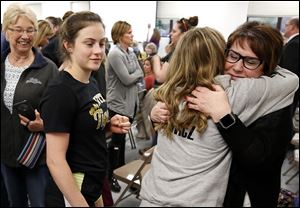 Former Toth student Bailey Lewicz, front, hugs Beth Christoff as the board members go into executive session during a Perrysburg Board of Education meeting at the Perrysburg Schools Administrative Building in Perrysburg on Monday.