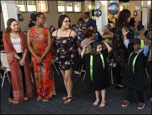 From left: Kathy Sharp (Polly Fox Academy), Rosalyn Whickum (University of Toledo), Cheyanne Garcia (Bowsher High School), Kayla Shay Goben and Gabriel Harris (Mom's House preschool) celebrate their graduation before the Mom's House Graduation ceremony at the Summit Event Center in Toledo.