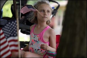 Brooklynn Richards, 6, watches the parade from her front yard during Memorial Sunday festivities in Rossford on May 27, 2018. Celebrations take place today in Sylvania, Perrysburg, Bowling Green, and Put-in-Bay.