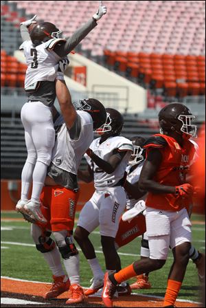 BGSU wide receiver RB Marlow III, 3, celebrates his touchdown pass with offensive lineman Sam Neverov during the scrimmage at Doyt Perry Stadium in Bowling Green, Ohio.