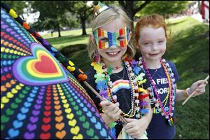 Sisters Jillian Casey-DeBacker, 8, left, and Olive, 6, were ready to go as they waited for the start of the Toledo Pride Parade along with their mothers Liz Casey and Jen DeBacker of Sylvania Saturday, along the parade route in downtown Toledo. 