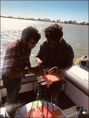 Sundeep Verma Gottumukkala, left, and Nirul Masurkar of the Wayne State MicroBuoy team work on a buoy before it is placed in Lake Erie.