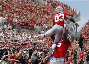 Ohio State receiver Terry McLaurin is lifted in celebration by teammate Jaylen Harris after scoring a touchdown against Oregon State on Saturday.