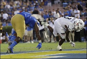 Central Catholic graduate and University of Cincinnati running back Michael Warren scores a touchdown Saturday against UCLA.
