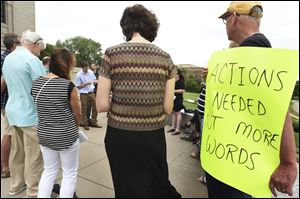 Rob Super, right, holds a sign as people gather outside the Cathedral of St. Paul in St. Paul, Minn., in August to demand action from the Catholic Church and show solidarity for victims of abuse. 