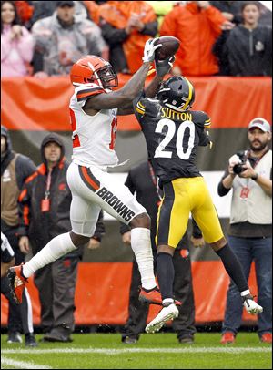 Cleveland Browns wide receiver Josh Gordon catches a 17-yard touchdown pass under pressure from Pittsburgh Steelers cornerback Cameron Sutton.