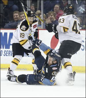 Matt Register (43) knocks down Toledo Walleye player Tyson Spink (12) during a game in May 2017.  