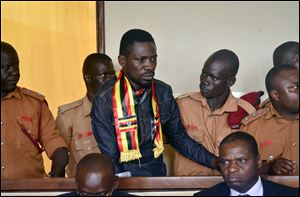 Ugandan pop star-turned-lawmaker Kyagulanyi Ssentamu, also known as Bobi Wine, center, arrives at a magistrate's court in Gulu, northern Uganda Thursday, Aug. 23, 2018.
