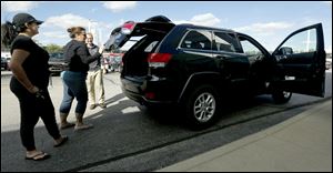 Paige Davis, 19, left, and her mom Tara Davis are shown a Jeep Grand Cherokee by sales advisor Ben Swonger to test drive at Yark Chrysler Jeep Dodge Ram in Toledo.