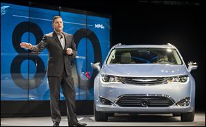 In this file photo, Tim Kuniskis shows off the 2017 Chrysler Pacifica Hybrid minivan at the North American International Auto Show, Monday, Jan. 11, 2016, in Detroit, Mich. 