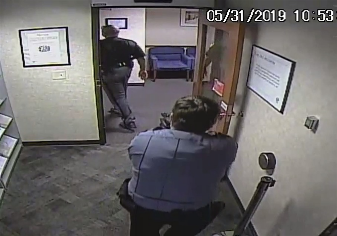 In a frame grab from security camera footage, security guard Seth Eklund is shown with his gun drawn on Lucas County Sheriff