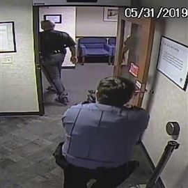 In a frame grab from security camera footage, security guard Seth Eklund is shown with his gun drawn on Lucas County Sheriff