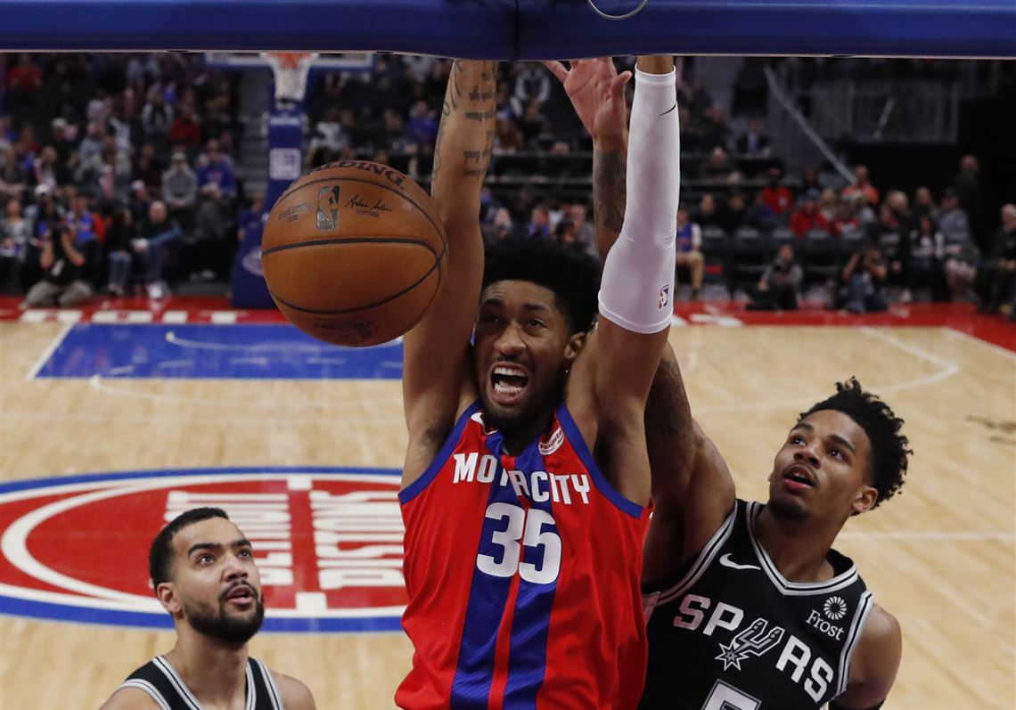 Detroit Pistons forward Christian Wood dunks as San Antonio Spurs guard Dejounte Murray (5) defends.