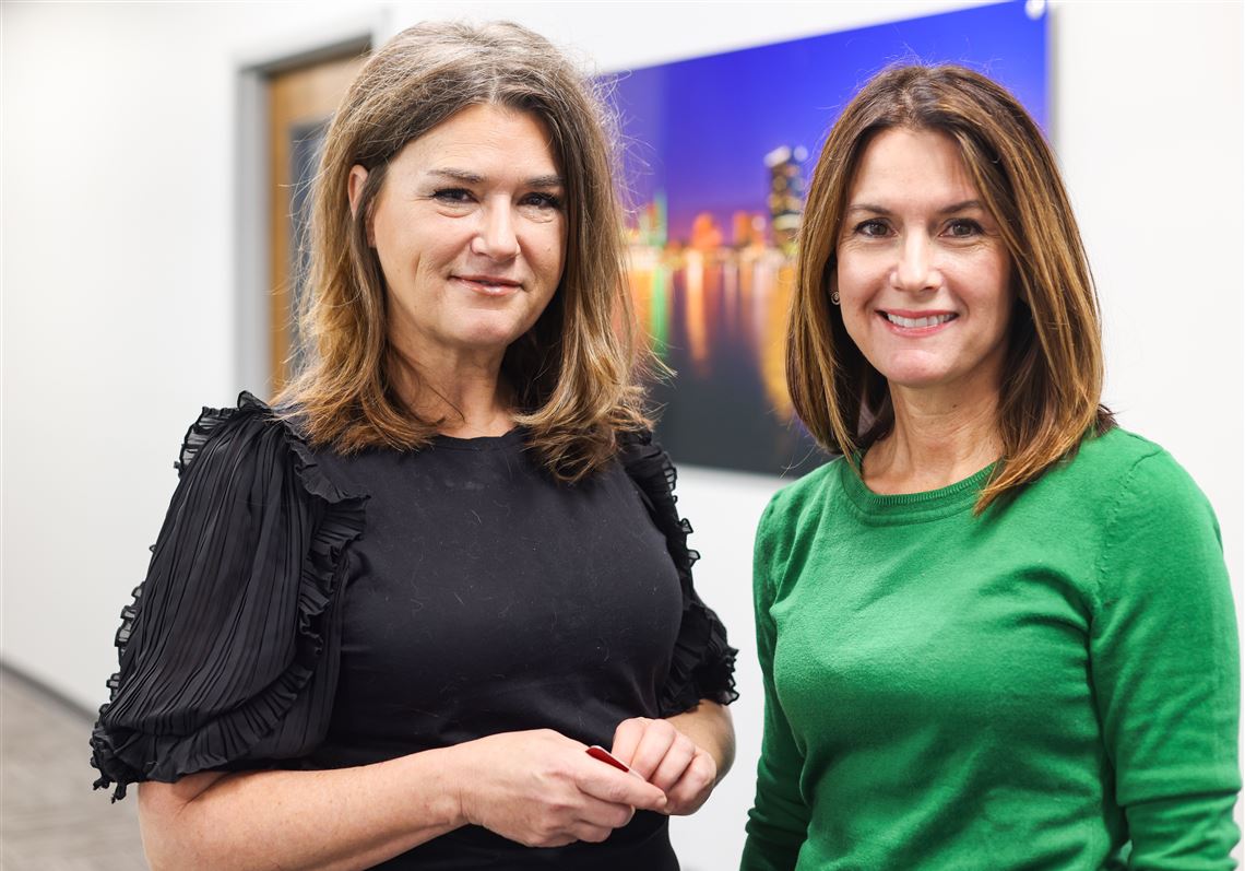 Caring Transitions wners Tami Herman and Amy Findlay pose for a photo in their new offices at Caring Transitions in Toledo.