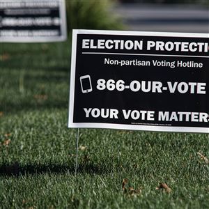 Signs with a voter hotline phone number are seen on Bancroft Street by University of Toledo in Toledo, Nov. 6. (THE BLADE/LIZZIE HEINTZ)