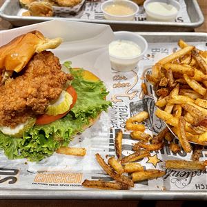 Super Chix's deluxe sandwich, left, comes with a standout garlic aioli that sets it apart from similar menu items at other chains. At right is a side order of Cajun-seasoned fries temporarily missing its cheese sauce.   (THE BLADE)