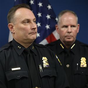 Newly named interim Police Chief Michael Troendle, left, and retiring Chief George Kral, listen as Toledo Mayor Wade Kapszukiewicz speaks during a news conference, Jan. 5, at One Government Center.