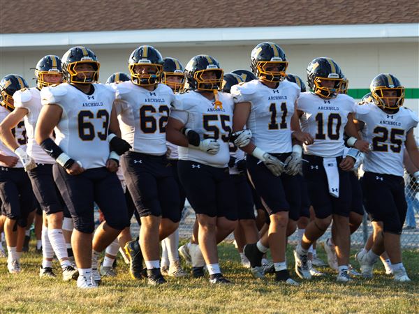 Archbold football players enter the field as Delta hosts Archbold on Sept. 12.