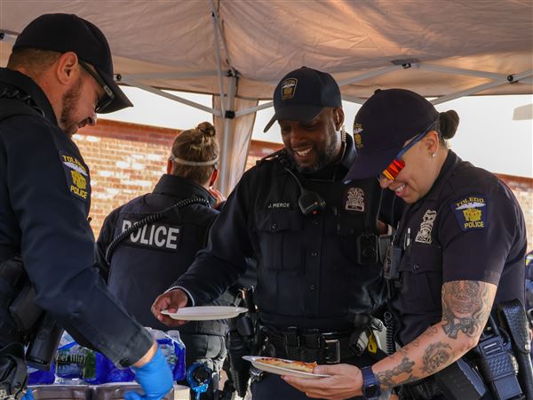TPD officer Francesca Fonseca grabs pizza with locals at the "Pizza with the Police!" event at the Western Ave. Marco's Pizza on Oct. 21 in South Toledo.