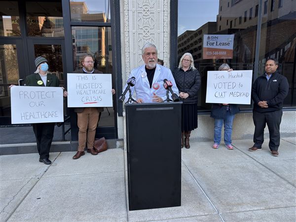 Dr. Johnathon Ross stands outside of U.S. Sen. Jon Husted's office in downtown Toledo on Thursday to voice concerns over the expiration of Affordable Care Act subsidies.