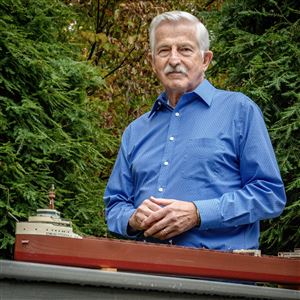 Former Blade Editor Tom Walton stands with his model of the Edmund Fitzgerald on Nov. 7 in Sylvania Township.