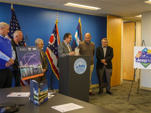 Owens Corning president Marcio Sandri presents an official invitation from Londrina, Brazil to Toledo Mayor Wade Kapszukiewicz for its own inaugural Jeep Fest modeled after Toledo's in the mayor's office of One Government Center on Nov. 13 in downtown Toledo.