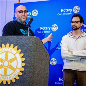 From left, Bryce Roberts, board chairman of Toledo Streets Newspaper, speaks as Vendor Manager at Toledo Streets Newspaper Ben Stalets, listens on Nov. 24 during the Toledo Rotary Club luncheon at the Glass City Center in Toledo.