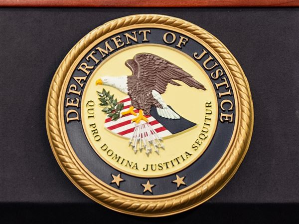 The Department of Justice logo is seen on a podium during a press conference at the U.S. Attorney's Office on Oct. 23.