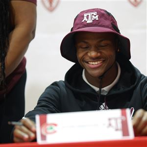 Victor Singleton signs to Texas A&M with family on Dec. 3 at Central Catholic High School in Toledo.