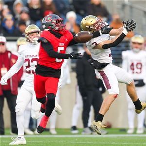 Central Catholic's Jerome Davis V (5) jumps for a ball as Bishop Waterson's Rocco Purcell misses an interception in the OHSAA Division III state title game on Dec. 5 at Tom Benson Hall of Fame Stadium in Canton.